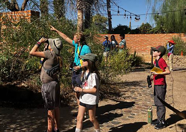 An educator shows campers around the Desert Garden